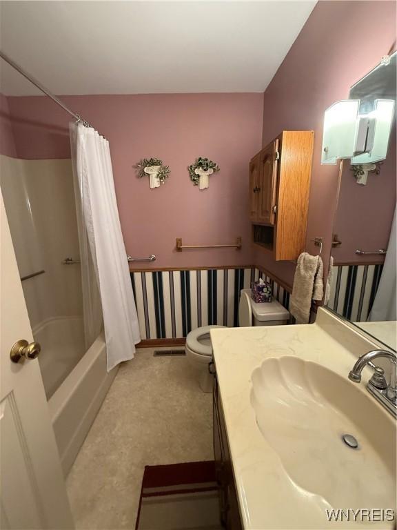 bathroom featuring shower / bath combination with curtain, vanity, and toilet