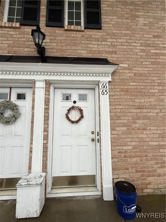 view of exterior entry with brick siding