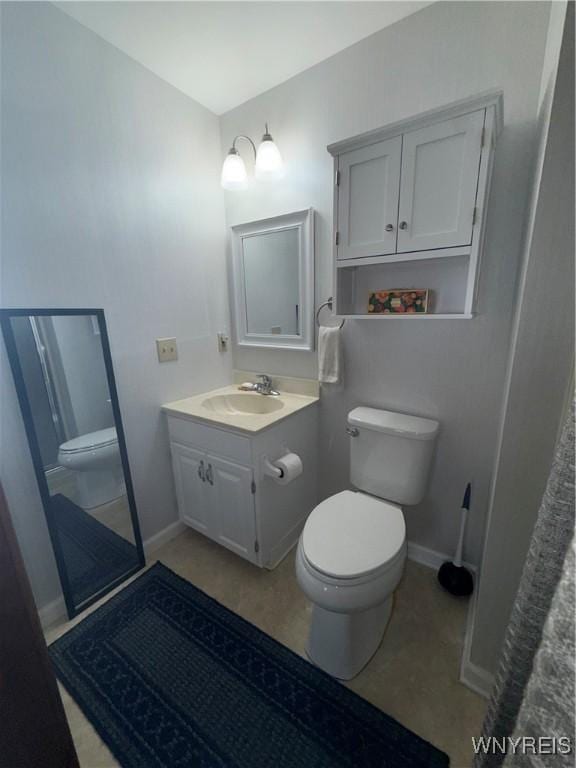 bathroom with baseboards, vanity, and toilet