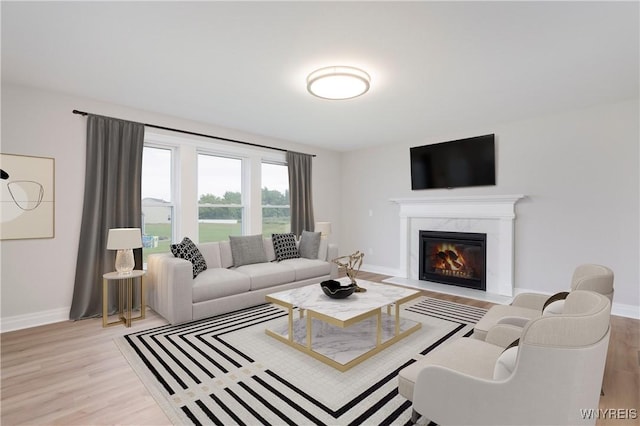 living room featuring light wood-style floors, baseboards, and a premium fireplace