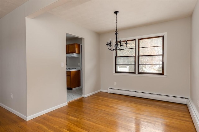 unfurnished dining area featuring a baseboard heating unit, light wood-style floors, baseboards, and an inviting chandelier