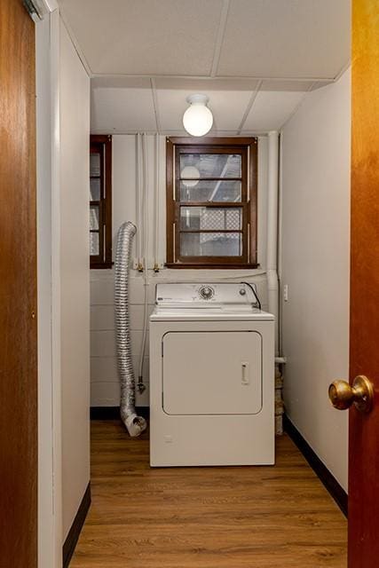 clothes washing area with light wood-style floors, washer / clothes dryer, baseboards, and laundry area