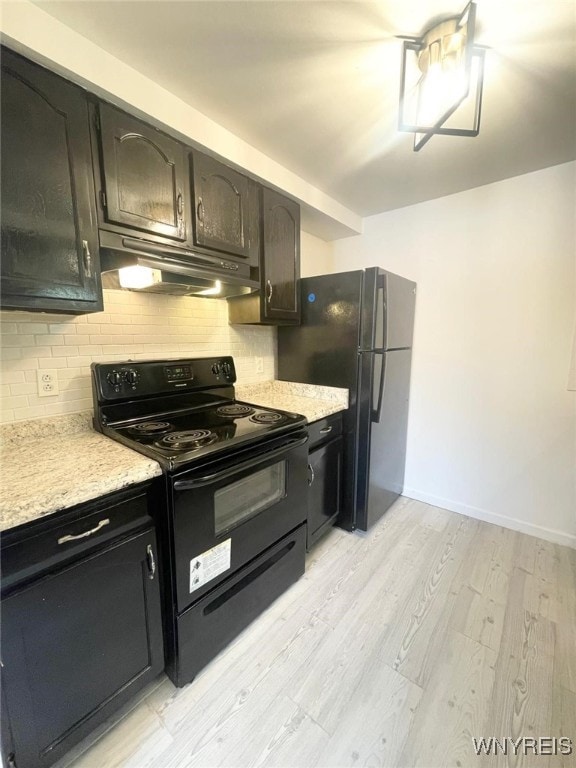 kitchen with under cabinet range hood, electric range, decorative backsplash, and light countertops