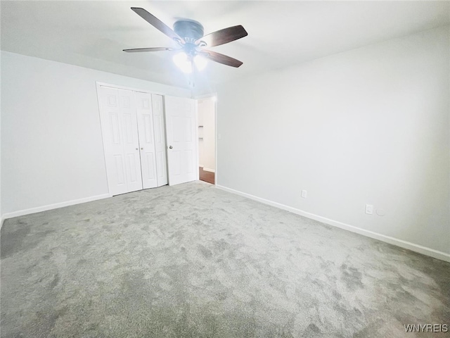 unfurnished bedroom with carpet, baseboards, ceiling fan, and a closet