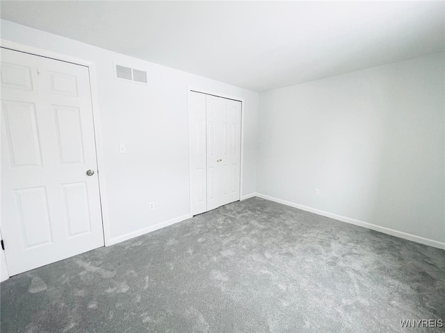 unfurnished bedroom featuring a closet, carpet flooring, visible vents, and baseboards