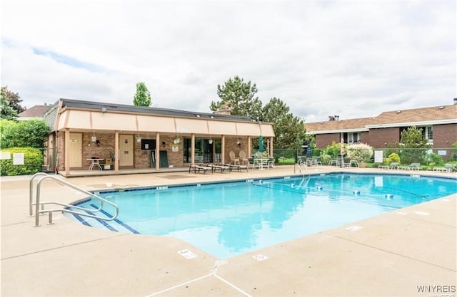 pool with a patio and fence