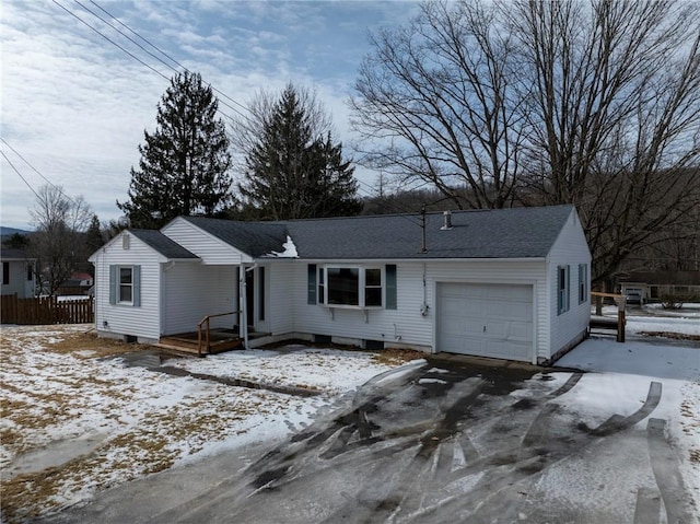 single story home featuring a shingled roof, fence, and an attached garage