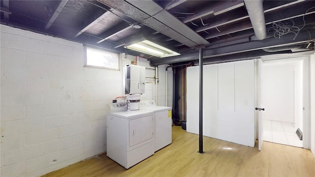 basement with light wood-style flooring and separate washer and dryer