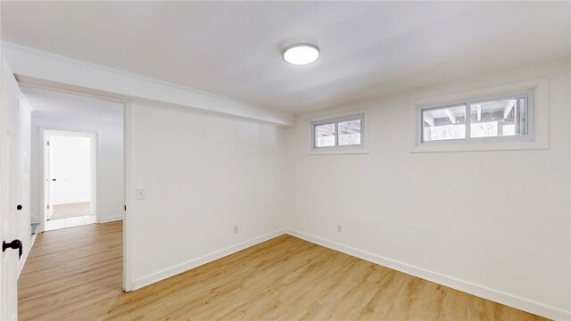 spare room featuring light wood-style floors and baseboards