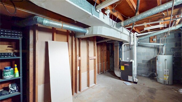 unfinished below grade area with water heater, concrete block wall, and heating unit