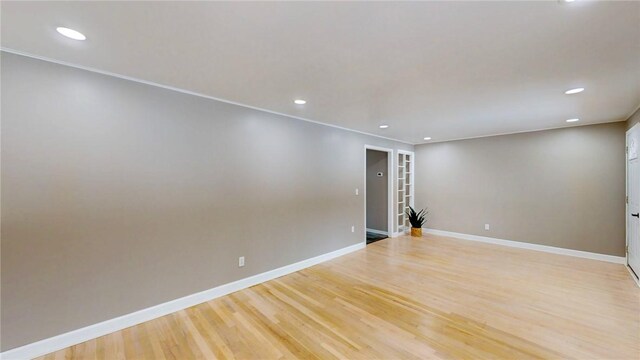 unfurnished room featuring light wood finished floors, baseboards, crown molding, and recessed lighting