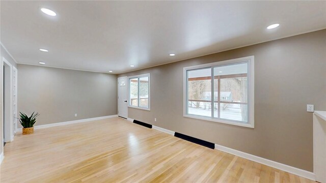 unfurnished living room with light wood finished floors, recessed lighting, and baseboards