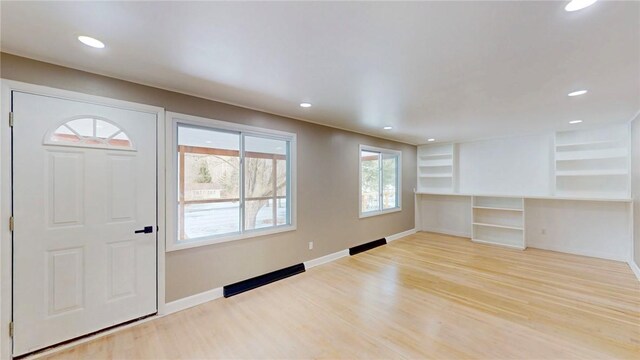 foyer entrance featuring baseboards, wood finished floors, and recessed lighting