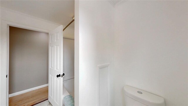 bathroom featuring baseboards, toilet, and wood finished floors