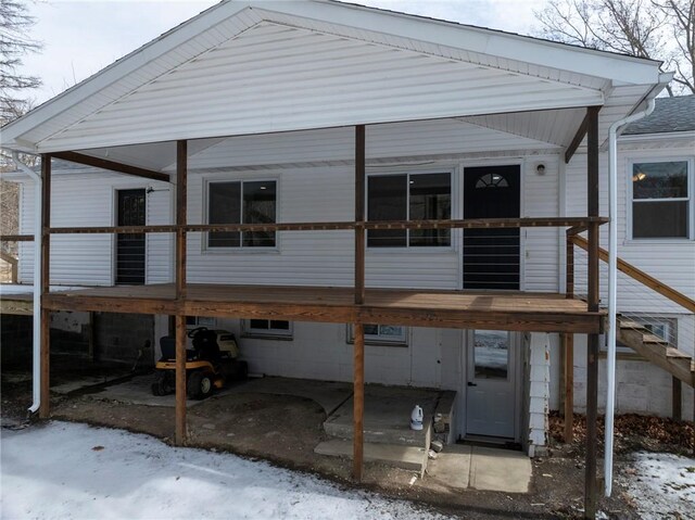 rear view of house featuring stairs, a carport, and a wooden deck