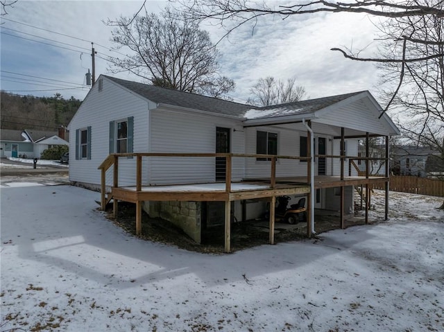 snow covered property with a wooden deck