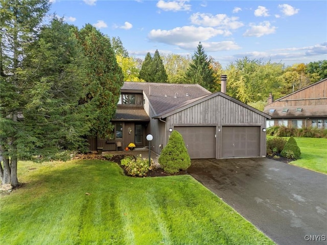 view of front of home featuring a garage, a front yard, driveway, and a shingled roof