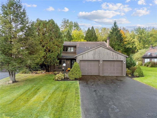 view of front of house with aphalt driveway, a garage, and a front lawn