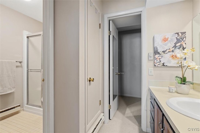 bathroom with a stall shower, a baseboard radiator, and vanity