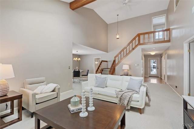 living area featuring high vaulted ceiling, stairway, beam ceiling, and an inviting chandelier