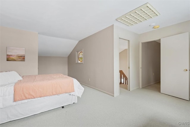 bedroom with carpet floors, baseboards, visible vents, and lofted ceiling