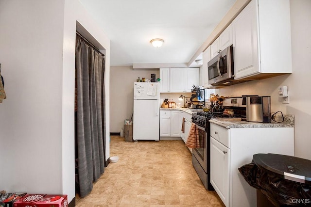 kitchen with light countertops, appliances with stainless steel finishes, and white cabinets