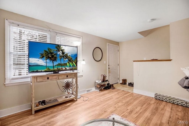 living room featuring baseboards, a wealth of natural light, and wood finished floors