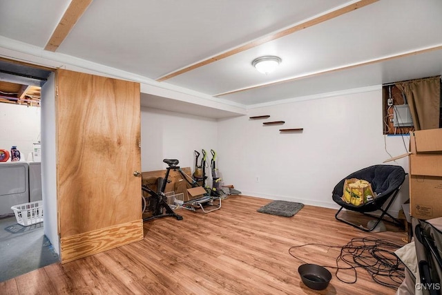 workout area with washer / clothes dryer, baseboards, and wood finished floors