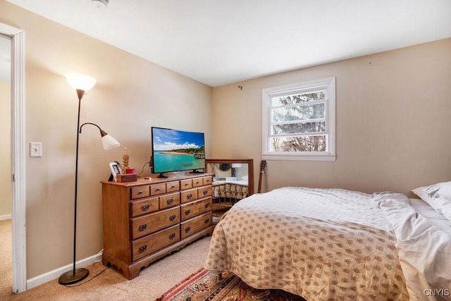 bedroom featuring light carpet and baseboards