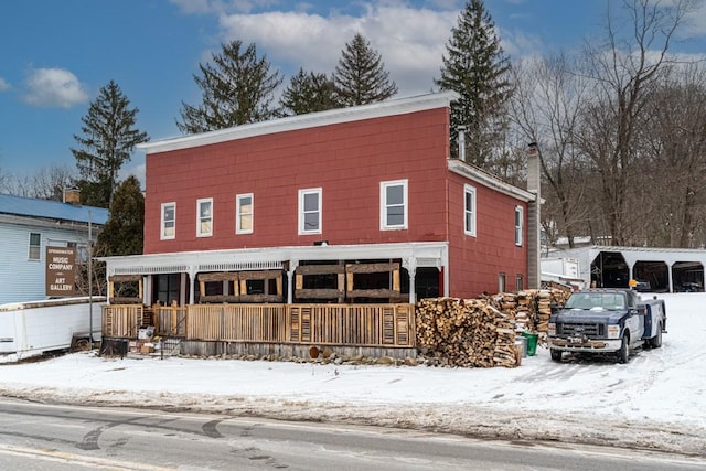 view of front of house with covered porch and a chimney