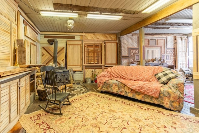 bedroom featuring wood ceiling, beamed ceiling, a wood stove, and wooden walls