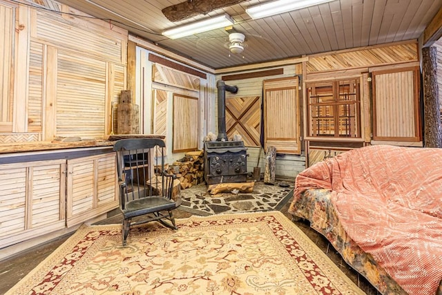 bedroom with a wood stove, wooden ceiling, and wooden walls