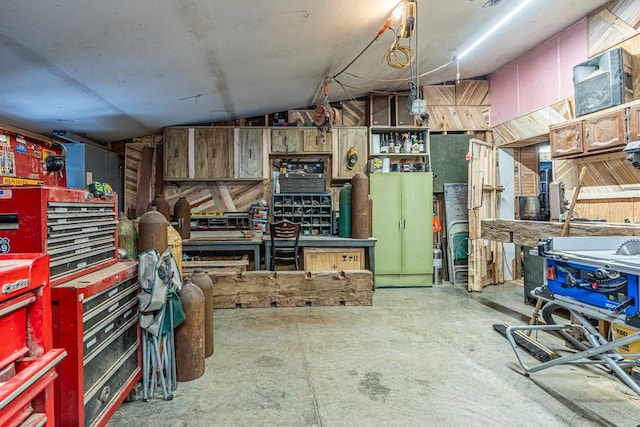 interior space featuring concrete floors, vaulted ceiling, and a workshop area