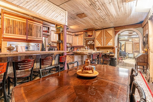 dining room featuring wooden ceiling and arched walkways