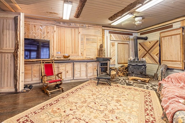 interior space with wood ceiling, wood walls, wood finished floors, and a wood stove