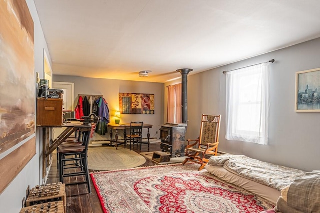 bedroom with a wood stove and wood finished floors