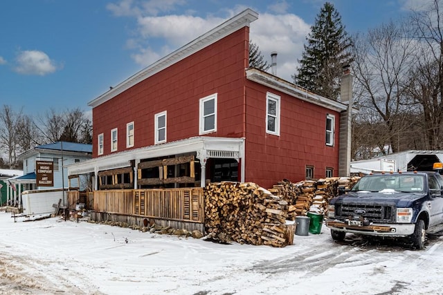 view of snowy exterior featuring a chimney