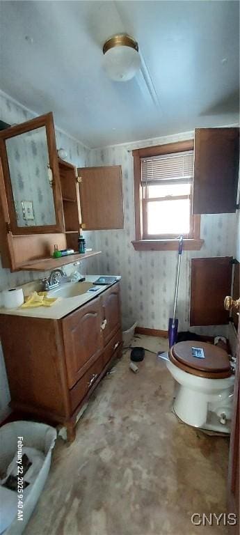 bathroom featuring vanity, toilet, and wallpapered walls