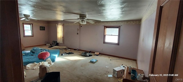 unfurnished bedroom featuring multiple windows, baseboards, and a ceiling fan