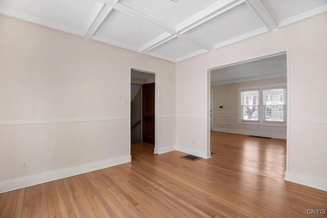 spare room featuring light wood finished floors, baseboards, visible vents, and coffered ceiling