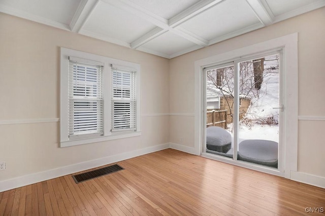 spare room with coffered ceiling, baseboards, visible vents, and hardwood / wood-style floors