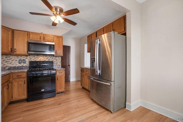 kitchen with stainless steel appliances, brown cabinets, light wood-style floors, and tasteful backsplash