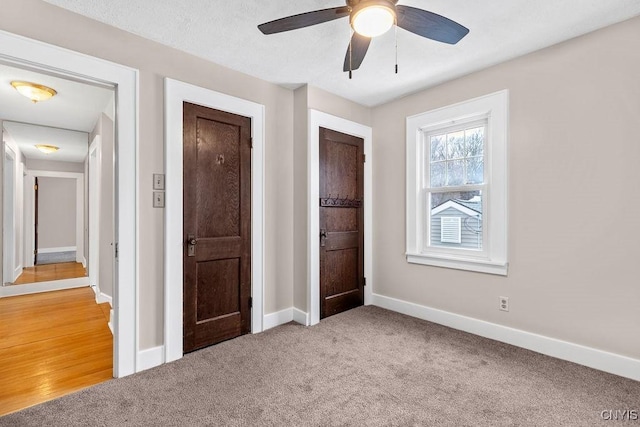 unfurnished bedroom with light carpet, baseboards, and a ceiling fan