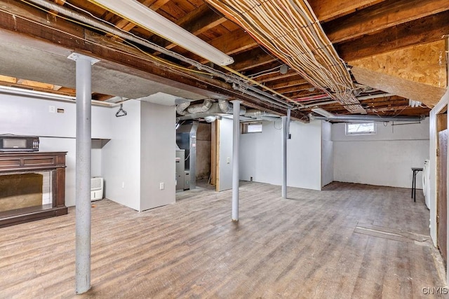 basement featuring heating unit and wood finished floors