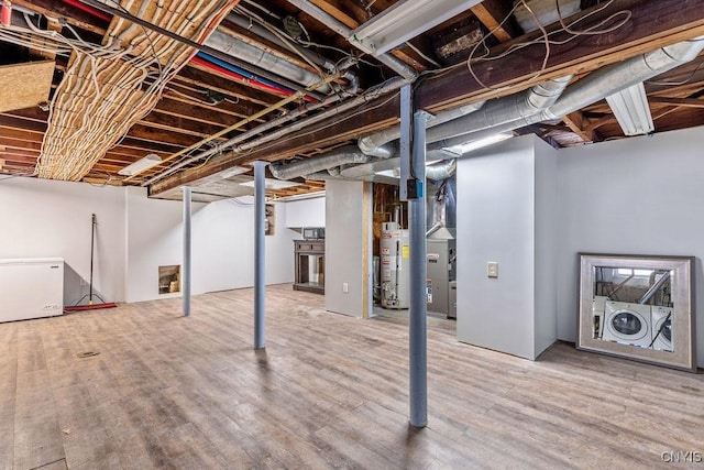 unfinished basement with separate washer and dryer, gas water heater, and wood finished floors