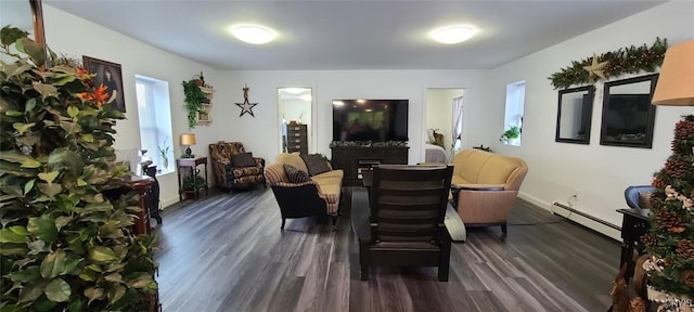 living area with a baseboard radiator, a fireplace, baseboards, and dark wood finished floors