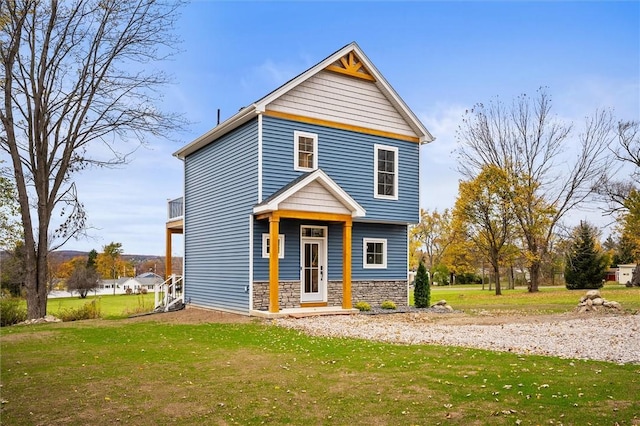 view of front of house featuring stone siding and a front yard