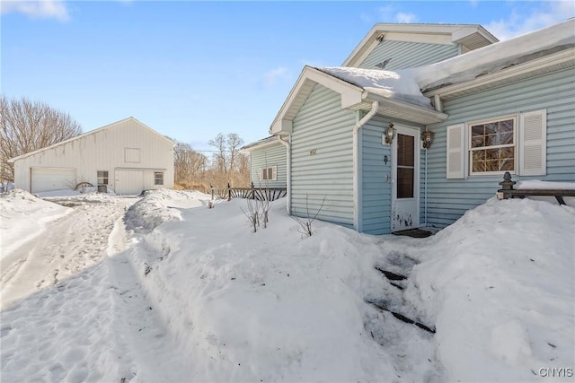 view of snow covered exterior with an outbuilding