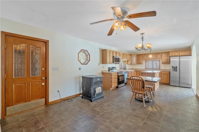 kitchen featuring baseboards, decorative light fixtures, stainless steel appliances, light countertops, and a sink