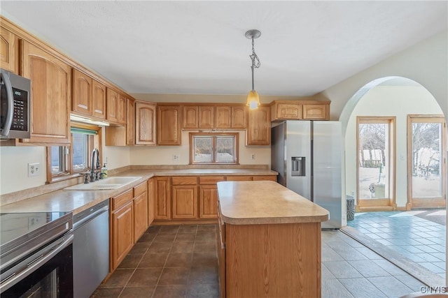 kitchen with light countertops, appliances with stainless steel finishes, dark tile patterned floors, and a sink